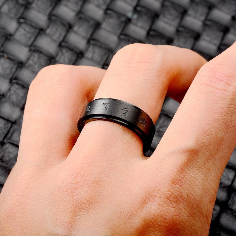 Person wearing a matte black engraved ring, showcasing its modern and masculine design.